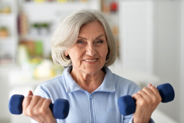 Portrait of elderly woman posing and exercising in gym