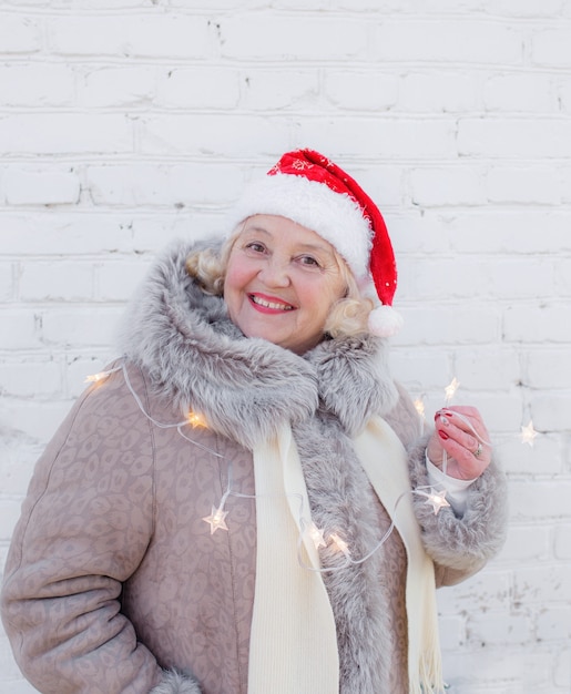 Portrait of an elderly woman in a red Santa hat