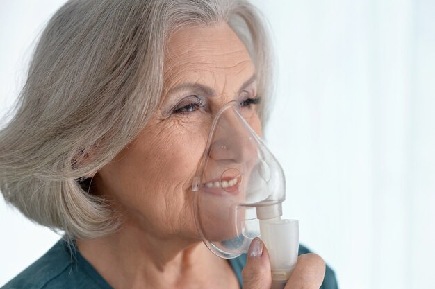 Portrait of elderly woman with flu inhalation