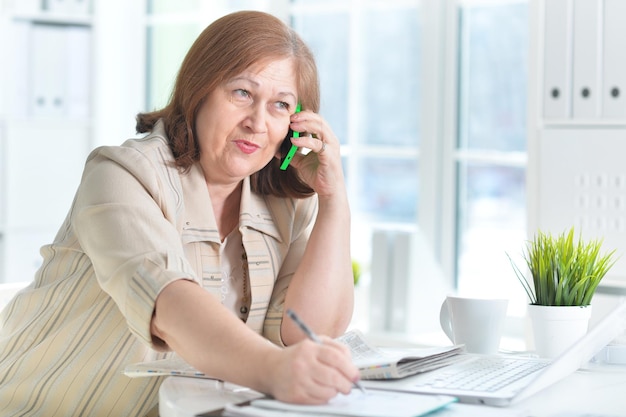 Portrait of an elderly woman with a laptop