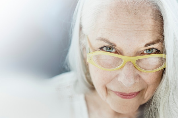 Photo portrait of an elderly woman with a yellow eyeglasses