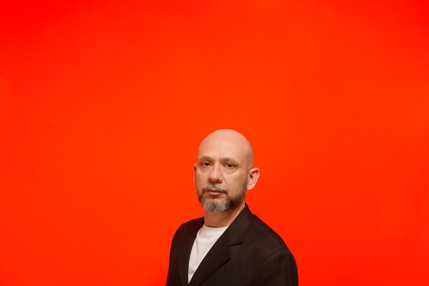 Portrait of an elegant business man looking at the camera isolated on orange background person