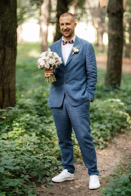 Photo portrait of an elegant groom in a blue suit