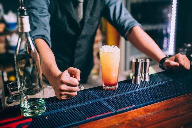 Foto ritratto di barman barista elegante e vintage che prepara cocktail di vodka e tequila a base di arancia