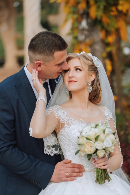 portrait of an elegant wedding couple tenderly embracing in a forest or park luxury bride and groom embracing romantic sensual moment