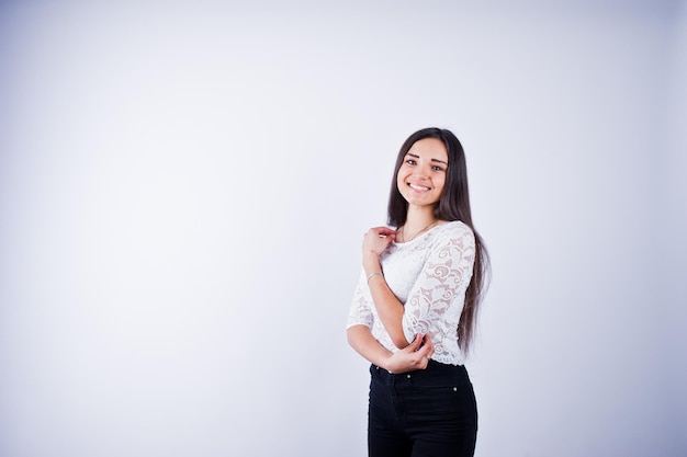 Portrait of an elegant young woman in white top and black pants in the studio