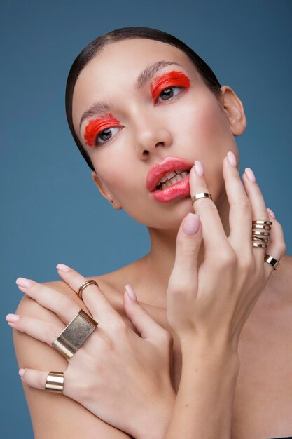 Portrait of an elegant young woman with red bright makeup on a blue background. Beauty fashion