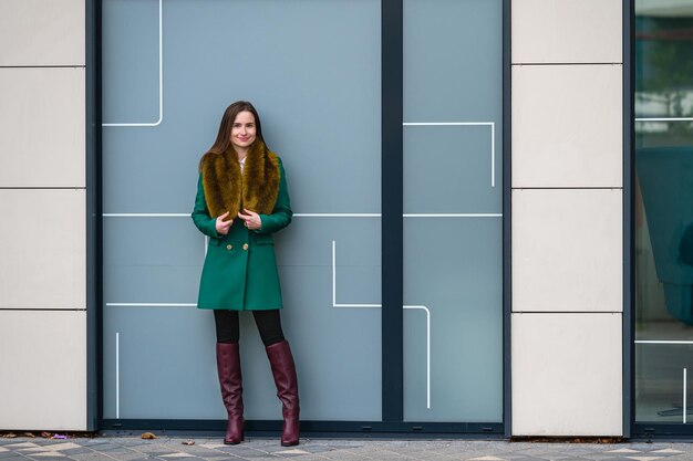 Photo portrait of an elegantly dressed business woman near a glazed building in the financial district