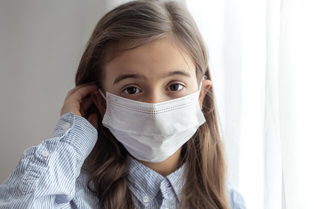 Portrait of a elementary school girl in a protective disposable mask