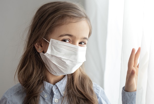 Portrait of a elementary school girl in a protective disposable mask