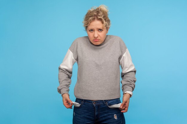 Portrait of emotional blonde woman on blue background