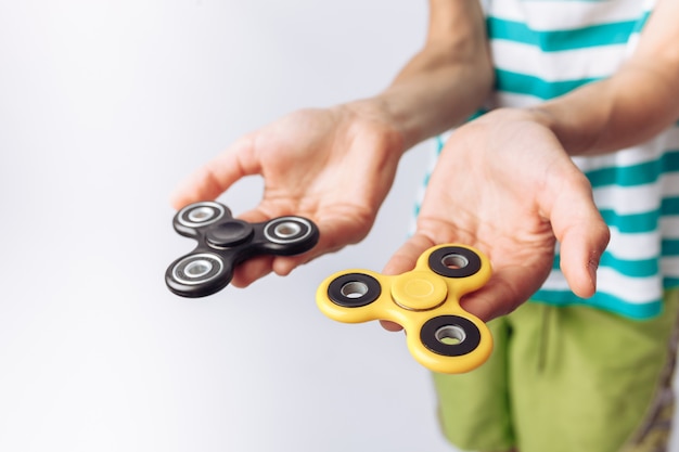 Photo portrait of a and emotional boy holding spinners