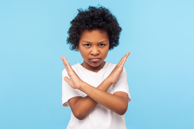 Portrait of emotional curly boy on blue background