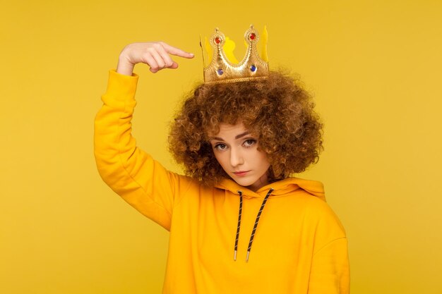 Portrait of emotional curly girl on yellow background