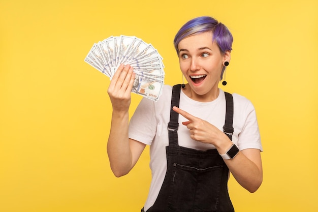 Portrait of emotional hipster woman on yellow background