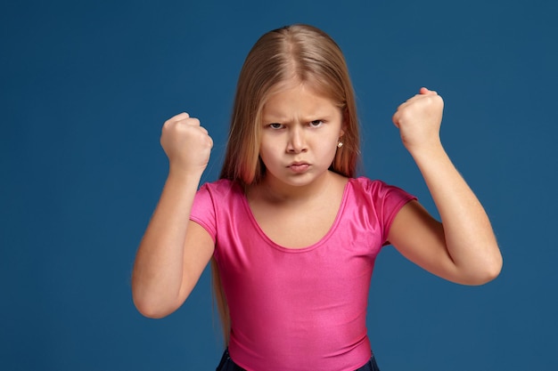 Portrait of emotional little girl on blue background