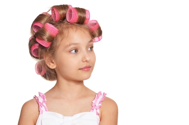 Photo portrait of emotional little pretty girl with hair curlers on white background