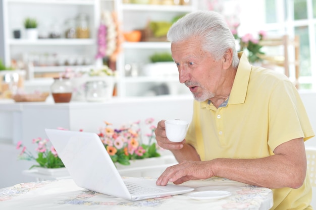 Portrait of emotional senior man using laptop