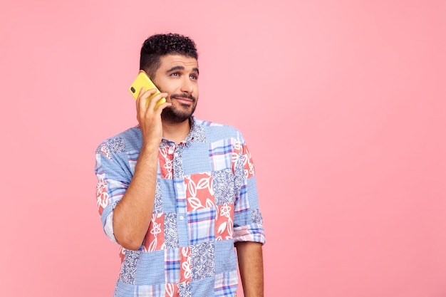 Portrait of emotional young bearded man on pink background