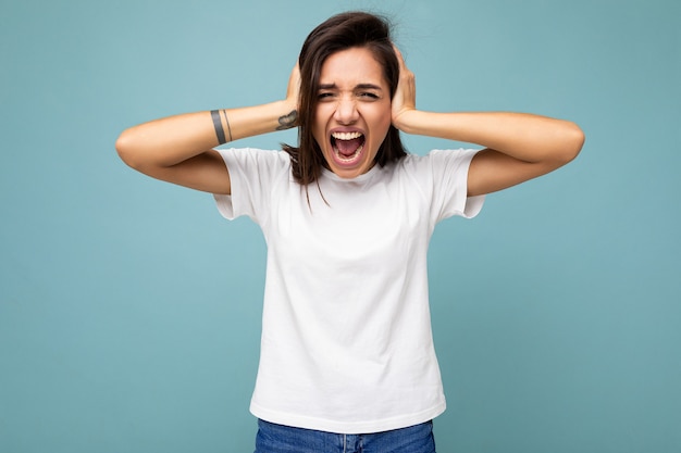 Portrait of emotional young beautiful brunette female person with sincere emotions