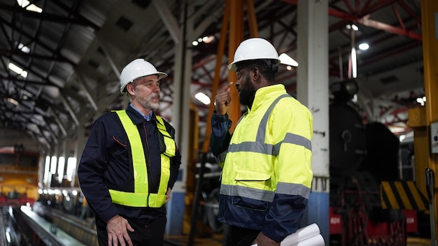 Portrait of engineer and apprentice in workshop of railway engineering facility