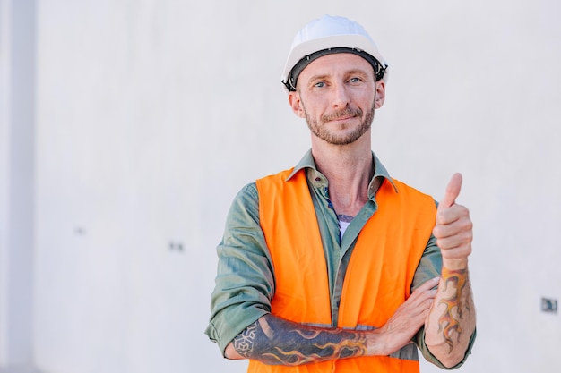 Foto lavoratore maschio dell'ingegnere del ritratto che sta mano sorridente thumbs up buon lavoro fatto passare il segno approvato