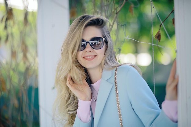 portrait of a european beautiful female model wearing sunglasses / girl outdoors walking, happy cheerful girl wearing glasses