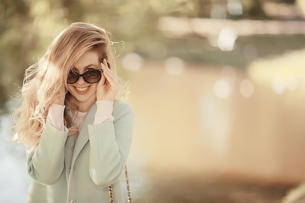 portrait of a european beautiful female model wearing sunglasses / girl outdoors walking, happy cheerful girl wearing glasses