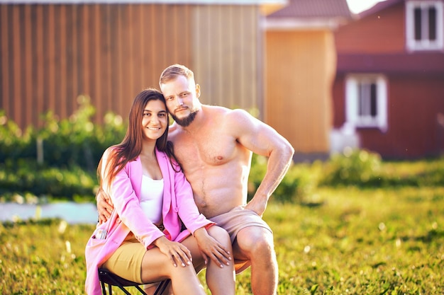 Photo portrait of european married couple in their s sitting in vegetable garden near their house