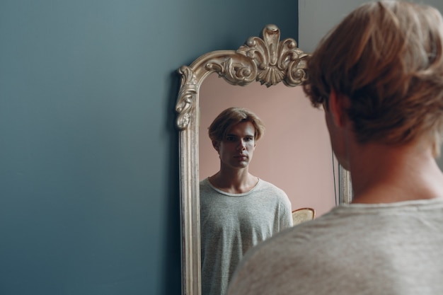 Photo portrait european young man with mirror portrait at studio indoor