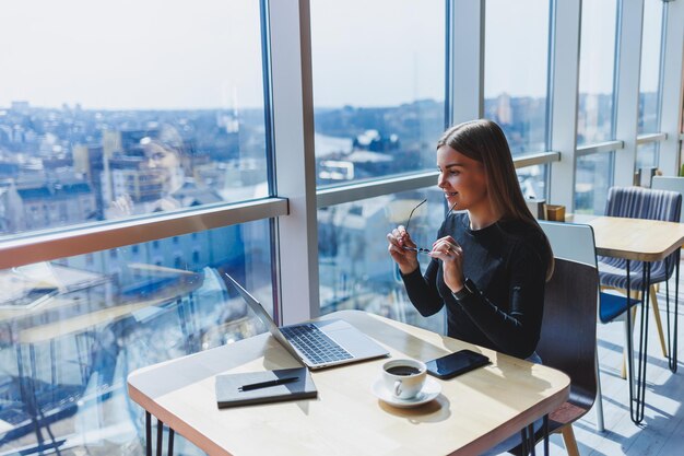 Foto ritratto di una giovane donna europea di successo seduta in un moderno caffè con laptop una bella freelance femminile si sta godendo il suo tempo libero in un caffè