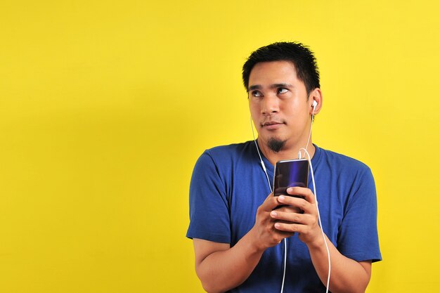 Portrait of excited Asian man surprised to find a trending song on online