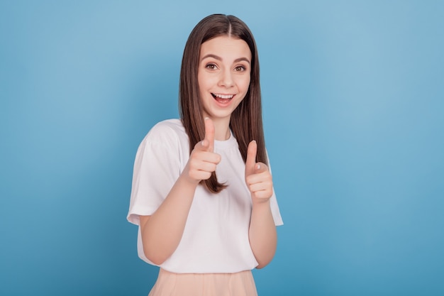 Portrait of excited crazy friendly cheerful nice lady forefingers direct camera on blue background