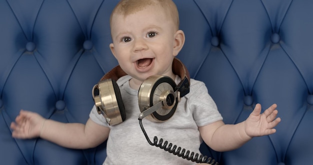 Photo portrait of excited girl wearing headphones on sofa