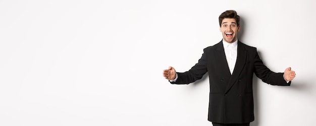 Photo portrait of excited handsome man in suit shaping big object on copy space and smiling amazed holding