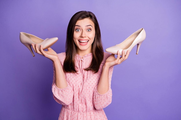 Portrait of excited pretty lady hold shoes good mood wear vintage