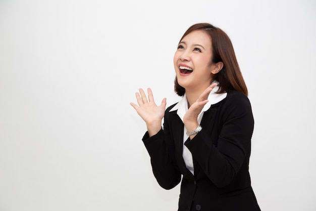 Portrait of excited screaming young asian businesswoman standing in business formal suit isolated over white