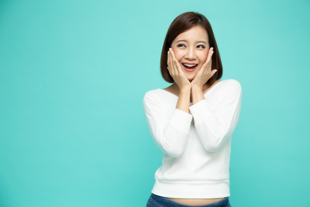 Portrait of excited screaming young asian woman standing isolated