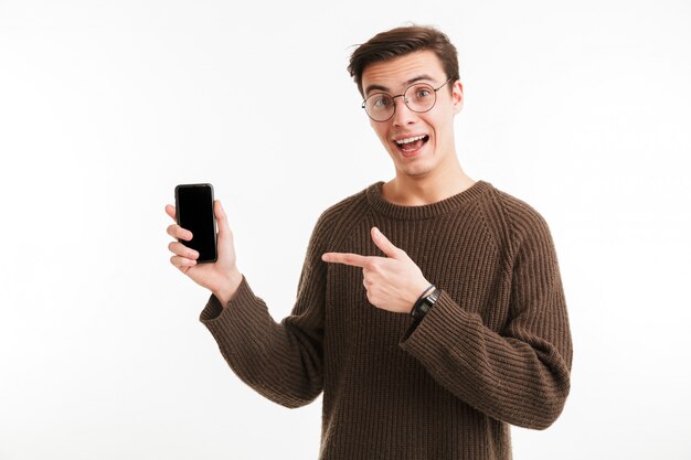 Portrait of an excited young man in sweater pointing finger