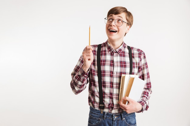 Portrait of an excited young school nerd guy holding book