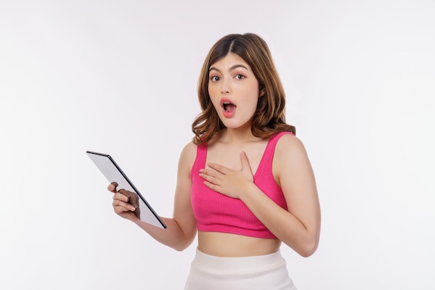 Portrait of excited young woman holding tablet isolated over white background