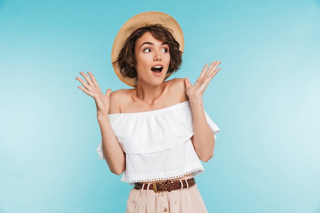 Portrait of an excited young woman in summer hat