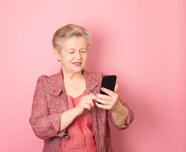 Portrait of exited senior woman granny using smartphone
