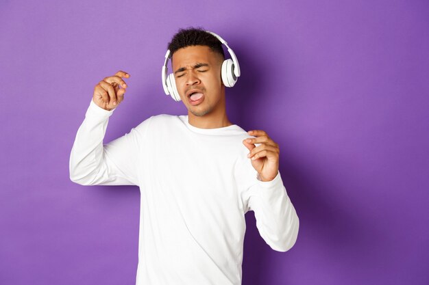 Portrait expressive young man listening music