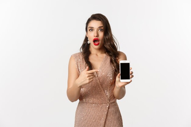 portrait expressive young woman in elegant dress holding phone