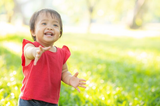 Portrait face of cute asian little girl and child happiness and fun in the park in the summer