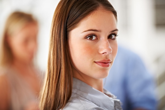 Photo portrait face and internship with a business woman in her office on a blurred background for career professional serious and confident with a young employee closeup in workplace of a design agency