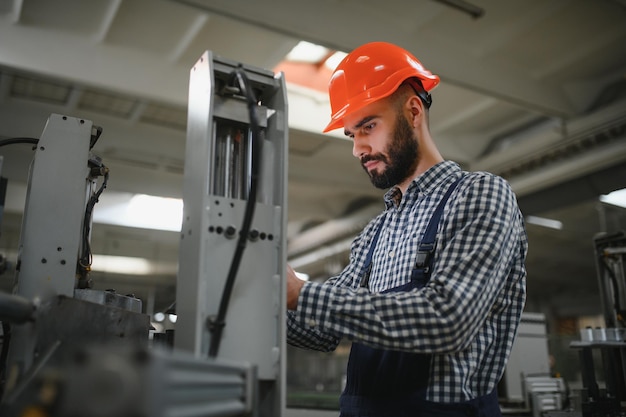 Portrait of factory worker in protective equipment in production hall