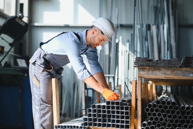 Photo portrait of factory worker in protective uniform and hardhat standing by industrial machine at production line people working in industry