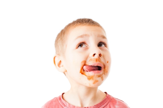 Photo portrait of fair-haired boy with chocolate on his face isolated on white. boy after cocoa drinking